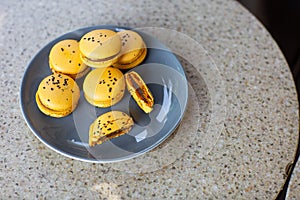Macaroons on a plate on a gray background. French macarons isolated. Selective focus. Beautiful yellow macaroons with