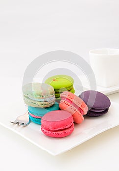 Macaroons on white plate and coffee cup