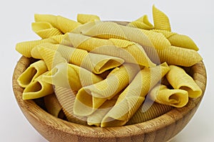 Maccheroni al pettine on wooden background. Raw italian pasta