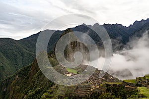 Macchu Picchu before sunrise covered in rising clouds