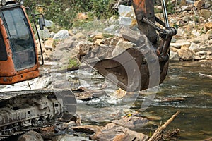 Camion pale scavando rocce sul compilare un fiume 