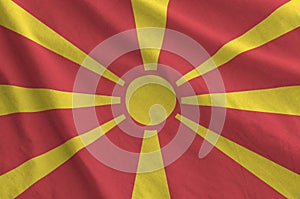 Macedonia flag depicted on folded wavy fabric of old cloth photo