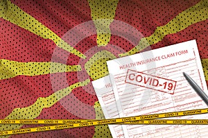 Macedonia flag and Health insurance claim form with covid-19 stamp. Coronavirus or 2019-nCov virus concept