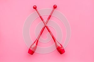 Maces for rhythmic gymnastics on pink background top view copy space