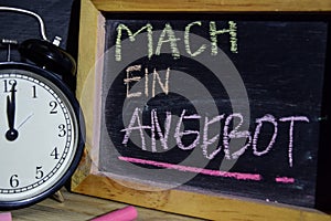 Mach ein angebot in germany on phrase colorful handwritten on blackboard.