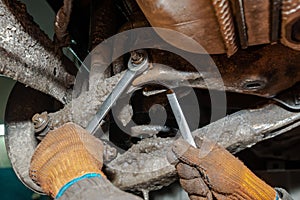 Machanic repairman at the car suspension repair in winter