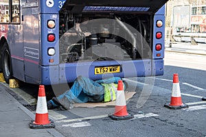 Machanic working on a broken down First Group bus with engine visible