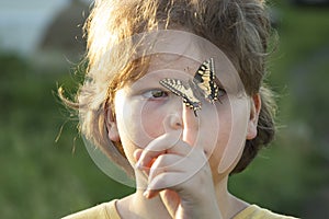 Machaon Butterfly on Child`s Hand at Summer Outdoors