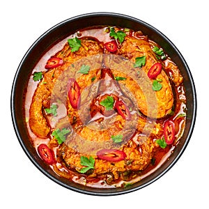 Macher Jhol in black bowl isolated on white. Indian cuisine Bengali Fish Curry. Asian food and meal. Top view