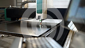 The machine cuts metal, close-up. A laser cutting machine cuts a metal plate. High-tech sheet metal production process