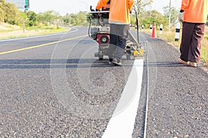 Machine eject and worker on road and traffic sign painting