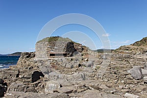 Machine-gun firing point DOT of the times of World War II, made of wild stone and disguised on the ground, at Cape Tobizin