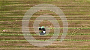 The machine and the harvester in the field are harvesting, aerial view.