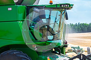 The machine for harvesting grain crops - combine harvester in action on rye field at sunny summer day. Agricultural machinery