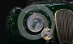 Vintage green car headlight close-up