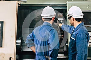 Machine maintenance service engineer team working together teamwork in factory back view