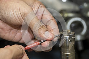 The machine operator changing the chip insert for indexable tool for rough cutter