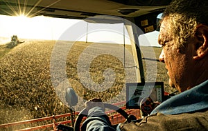 The machine operator at the helm of a modern combine harvester harvests grain