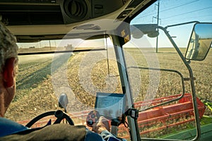 The machine operator at the helm of a modern combine harvester harvests grain
