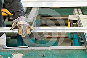 machine operator using safety gloves stretching an aluminiun profile with a straightener-stretcher machine photo