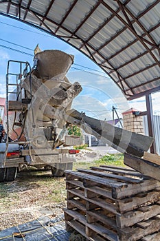 The machine is pouring concrete mix at a construction site.