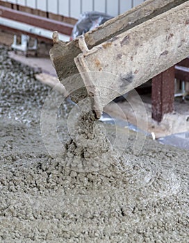 The machine is pouring concrete mix at a construction site.