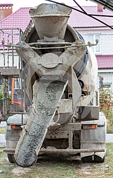 The machine is pouring concrete mix at a construction site.