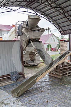 The machine is pouring concrete mix at a construction site.