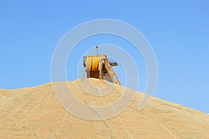 Machine is processing grain harvest in a blue sky, Australia