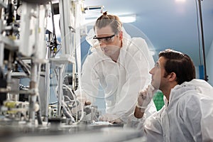 Machine staff, mask production department. Engineer wearing protective suit Inspecting quality of masks. machine production