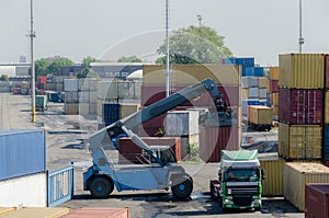 A machine unloading container cargoes from a truck in a railway depot