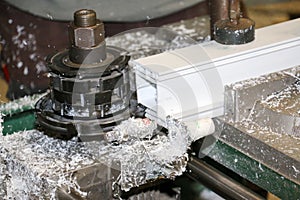 A machine works a profile in a carpentry specializing in PVC photo