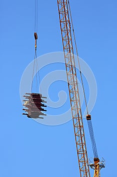 Machinery crane hoisting up steel rod bar in construction