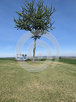 Machinery, equipment for plowing the ground, blue soil stands on green grass against the background of a blue sky.