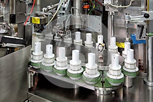 Machinery filling plastic tubes with healthcare products.