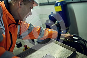 Machinery is his muse. a young engineer working with complicated machinery while wearing safety gear.