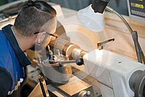 Machinery worker at lathe machine in workshop