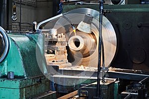 Machining oil-cooled part on a lathe, rotating parts blurred in motion