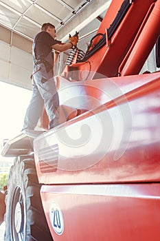 Machinist repairing a huge farm machine in his garage