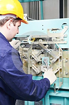 Machinist with spanner adjusting lift mechanism photo