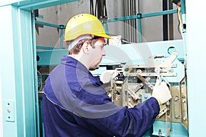 Machinist with spanner adjusting lift mechanism