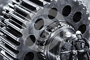 Machinists, engineers with giant cogwheels machinery