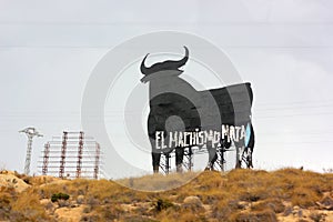 `Machismo kills` writing on a big shield shaped like a bull in Spain photo