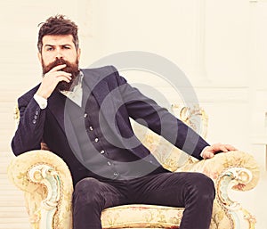 Macho attractive and elegant on serious face and thoughtful expression. Man with beard and mustache wearing classic suit