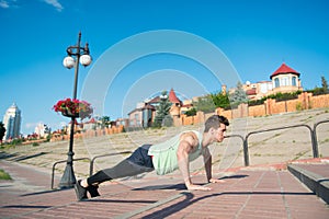 Macho doing pushups on red brick stairs outdoors