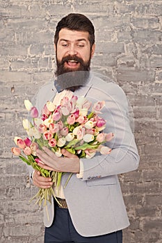 Macho getting ready romantic date. Tulips for sweetheart. Romantic gift. Man well groomed wear blue tuxedo bow tie hold
