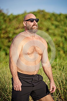 Macho guy on the beach with sunglasses on the weekend