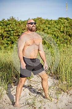 Macho guy on the beach with sunglasses on the weekend