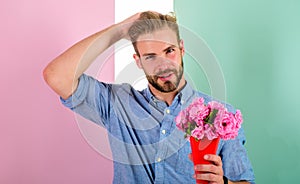 Macho holds bouquet as romantic gift. Guy bring romantic pleasant gift waiting for her. Man ready for date bring pink