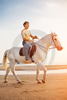 Macho man and horse on the background of sky and water. Boy mode photo